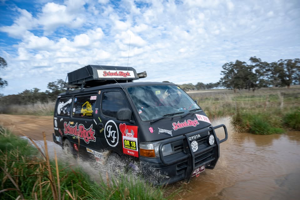 Crew crossing water in the black 'School of Rock' van during the Variety Bash