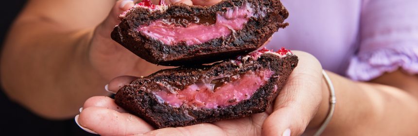 close up of mrs brownes bakes raspberry and chocolate pies cut in half held by a woman in a lavender coloured dress. The pie was deemed ballarat's best for 2025