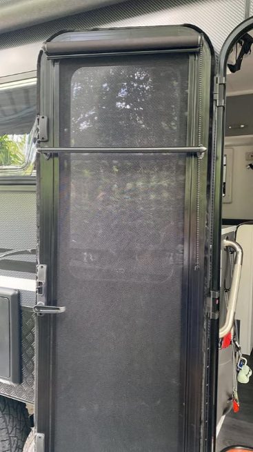 A curtain rod installed on the back facing side of a caravan door